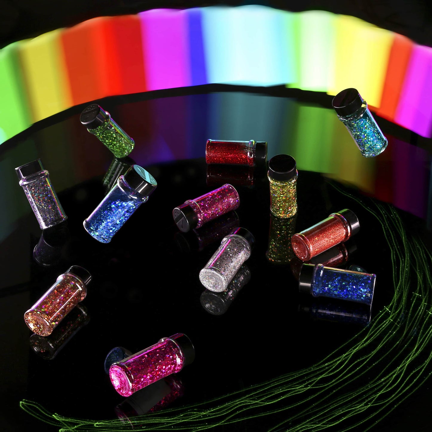 Colorful glitter jars on a reflective surface with a rainbow gradient background