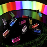 Colorful glitter jars on a reflective surface with a rainbow gradient background